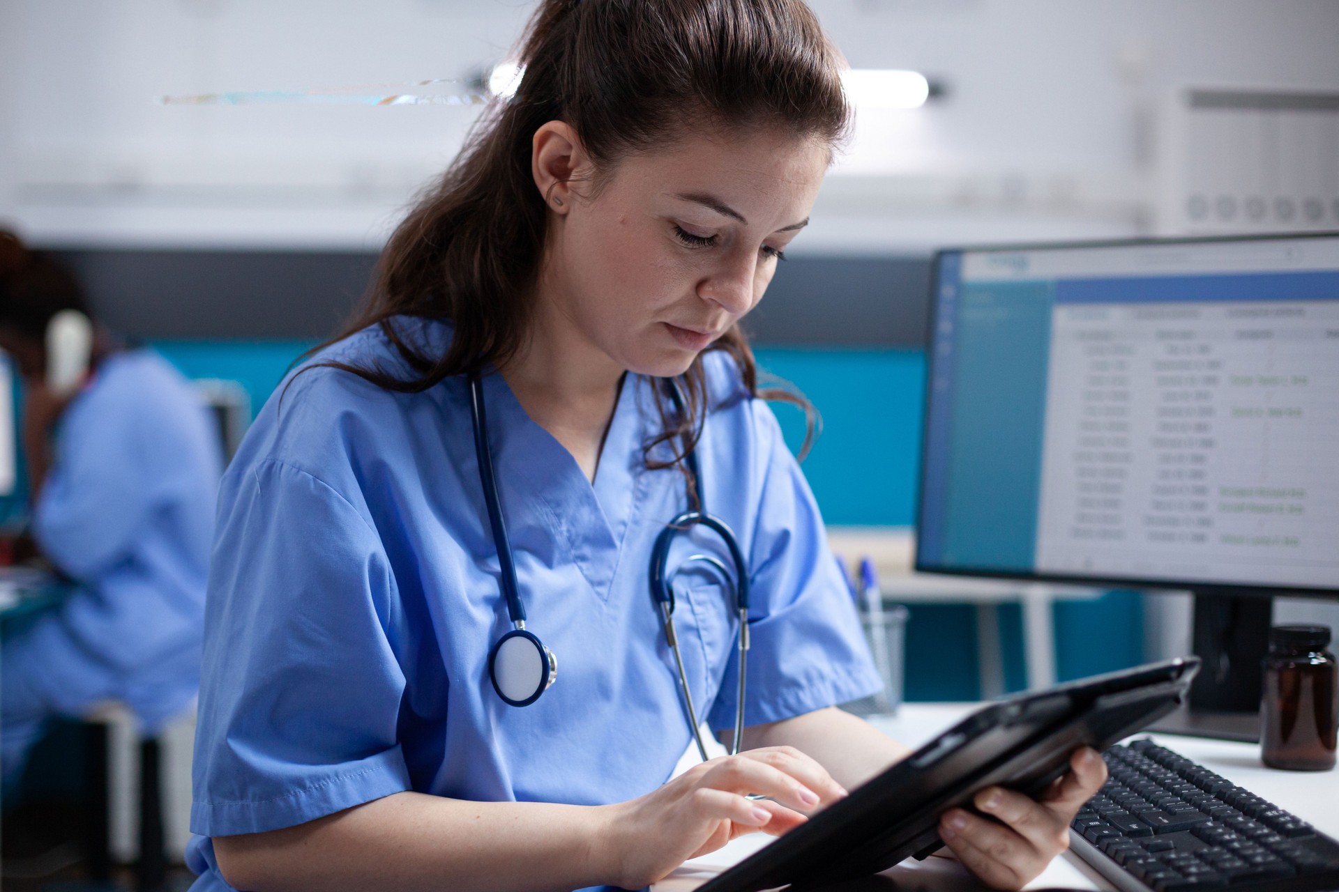 Nurse checking patient data on tablet
